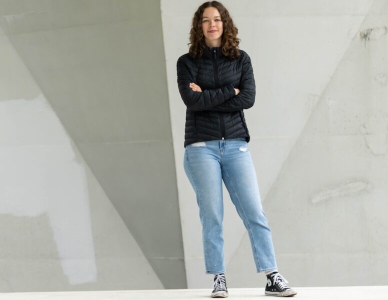 Elleda standing in front of a concrete wall