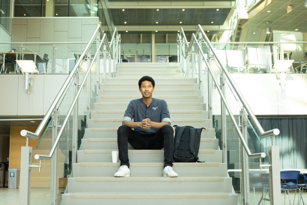 Rahman sitting on stairs at UBC Okanagan