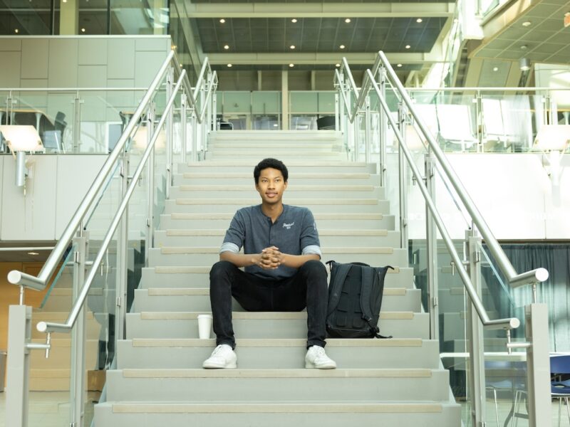 Rahman sitting on stairs at UBC Okanagan