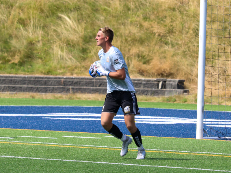 Axel playing soccer for UBC, holding the soccer ball